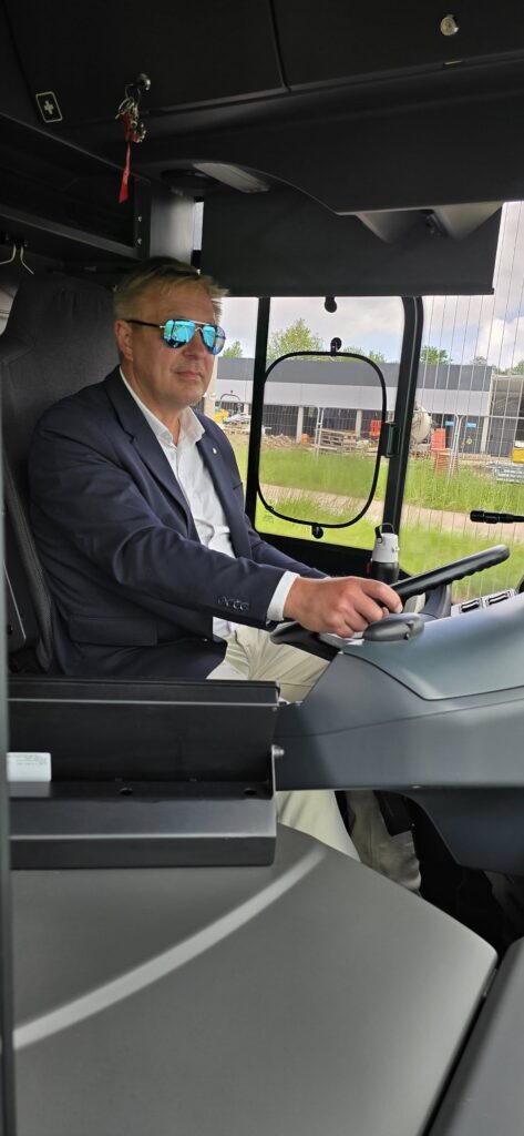 Kierowca siedzi za kierownicą autobusu wodorowego MZUK podczas wycieczki przedszkolaków.